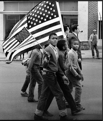 Black boys marching with flags for voting rights